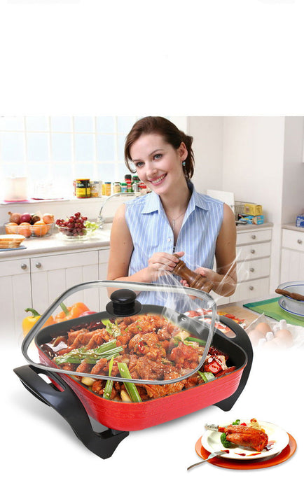 Woman in a kitchen with a large cooking pot containing food, smiling at the camera.