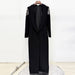 Black long coat with decorative sleeves on a white background