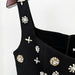 Black top with decorative pearl embellishments on a white background