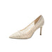 Beige high-heeled shoe with glittery texture on a white background