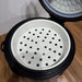 Black and white steamer basket on a wooden surface