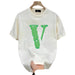 White t-shirt with green logo held by a hand on a white background