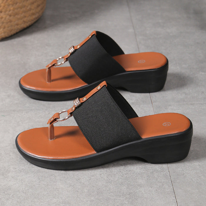 Pair of black and orange sandals on a gray floor