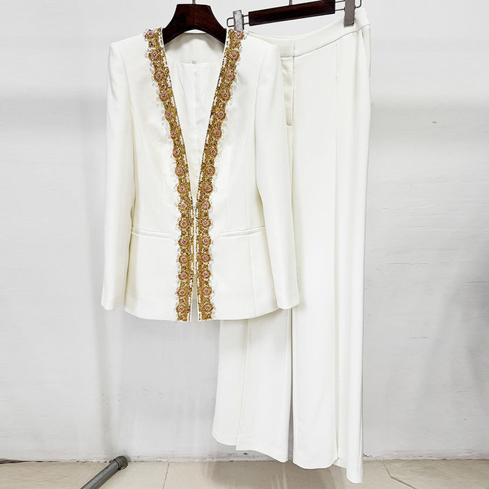 White outfit with gold embroidery on a hanger against a white background