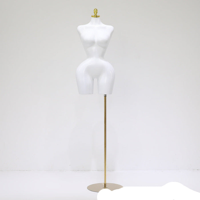 White mannequin torso on a brass stand against a white background