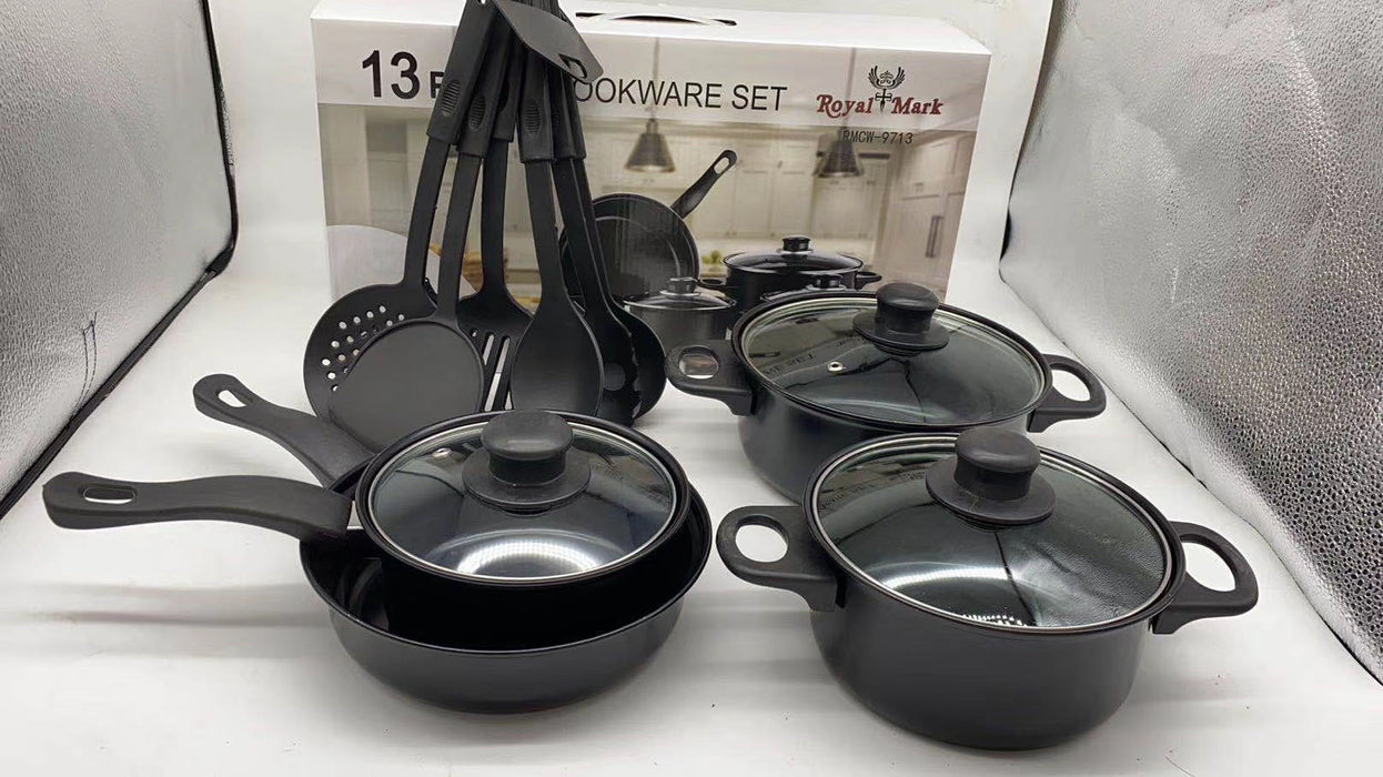 Set of black cookware with lids on a white surface, with a box labeled 'Royal Mark' in the background.