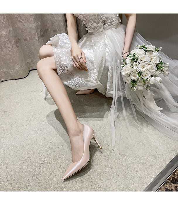 Bride in a white dress with a bouquet sitting on the floor.