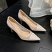 Pair of beige high-heeled shoes on a dark surface