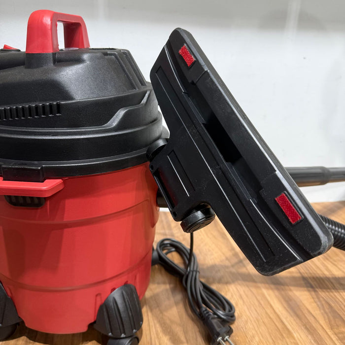 Red and black vacuum cleaner on a wooden surface
