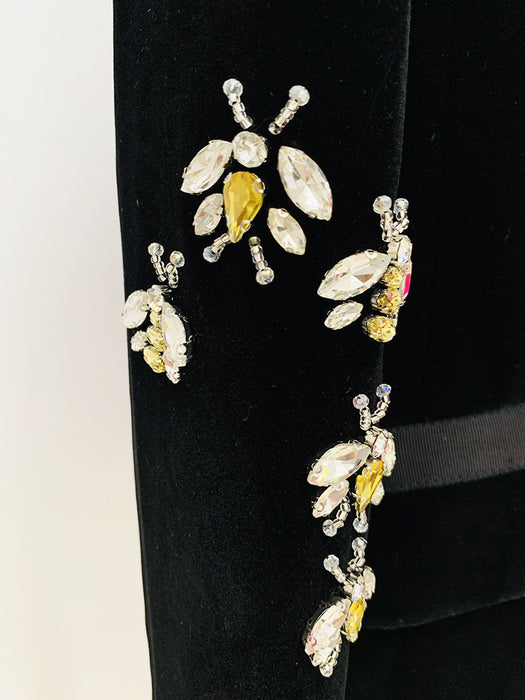Decorative earrings with yellow and clear gemstones on a black background