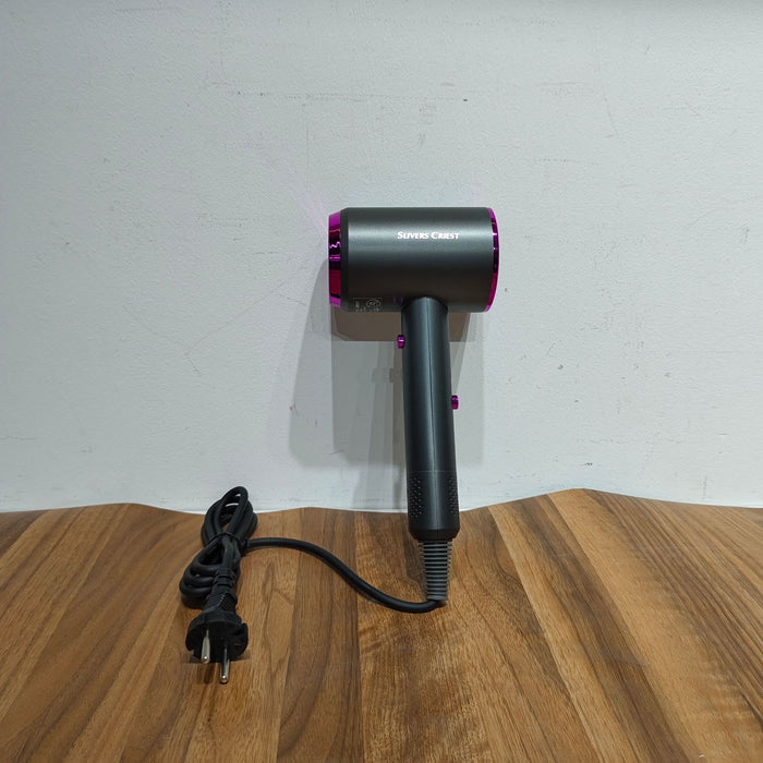 Black and purple hair dryer on a wooden surface with a white wall background