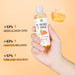 Hand holding a bottle of Tumeric Toner with product features on an orange background