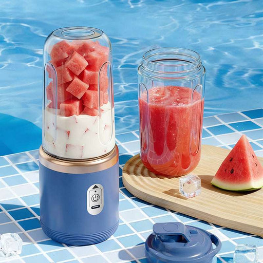 Portable blender with watermelon pieces and a glass of watermelon juice on a poolside table.
