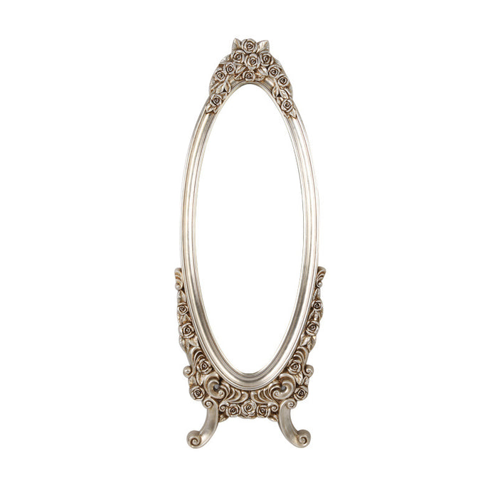 Decorative oval mirror with intricate design on a white background