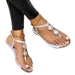 White sandals with decorative elements worn by a person on a white background
