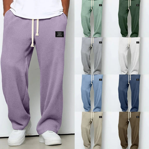 Purple textured sweatpants with a white shirt and white sneakers, displayed against a white background.