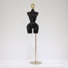 Black mannequin torso on a gold stand against a white background