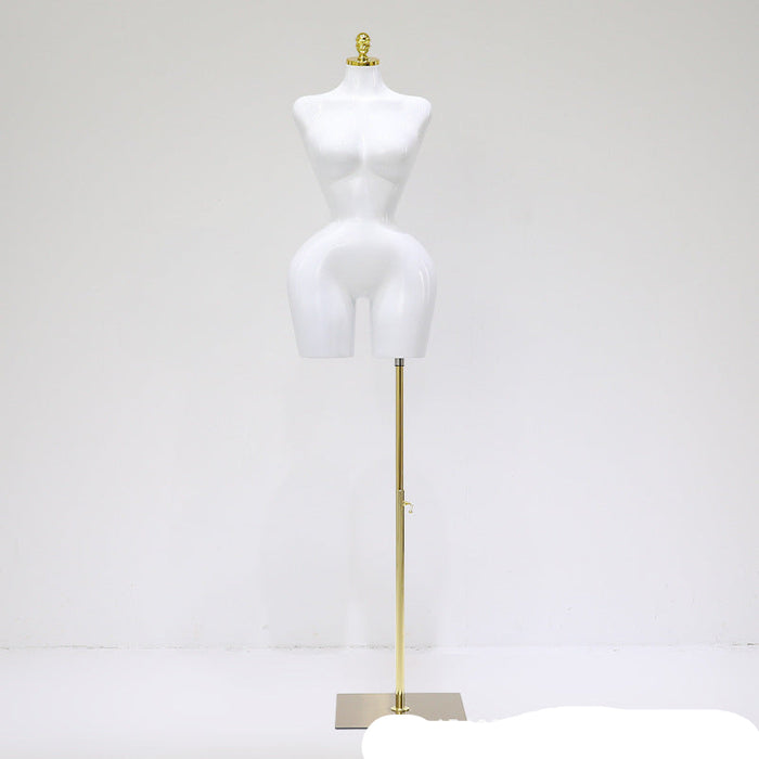 White mannequin torso on a gold stand against a white background