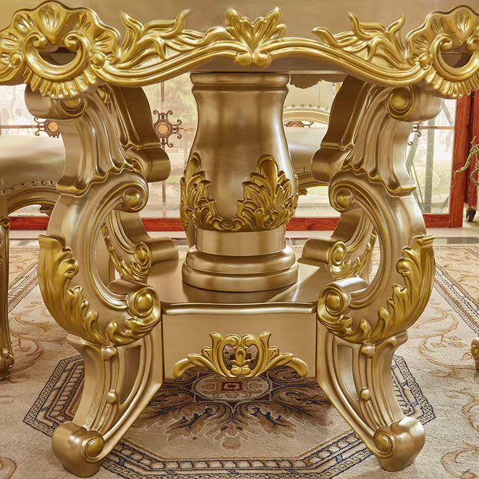 Gold ornate table in a luxurious room with red carpet and decorative elements.