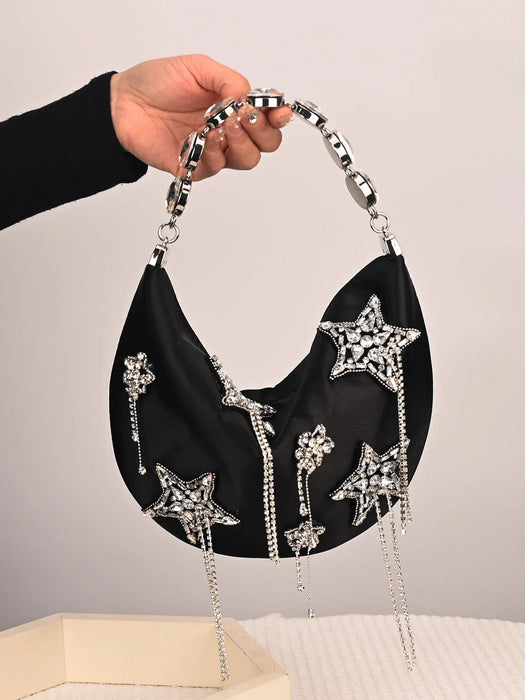 Black handbag with star-shaped embellishments held by a hand against a neutral background