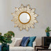 Decorative sun-shaped mirror on a wall above a sofa with colorful pillows.