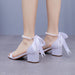 White sandals with ribbons and pearl anklets on a neutral background