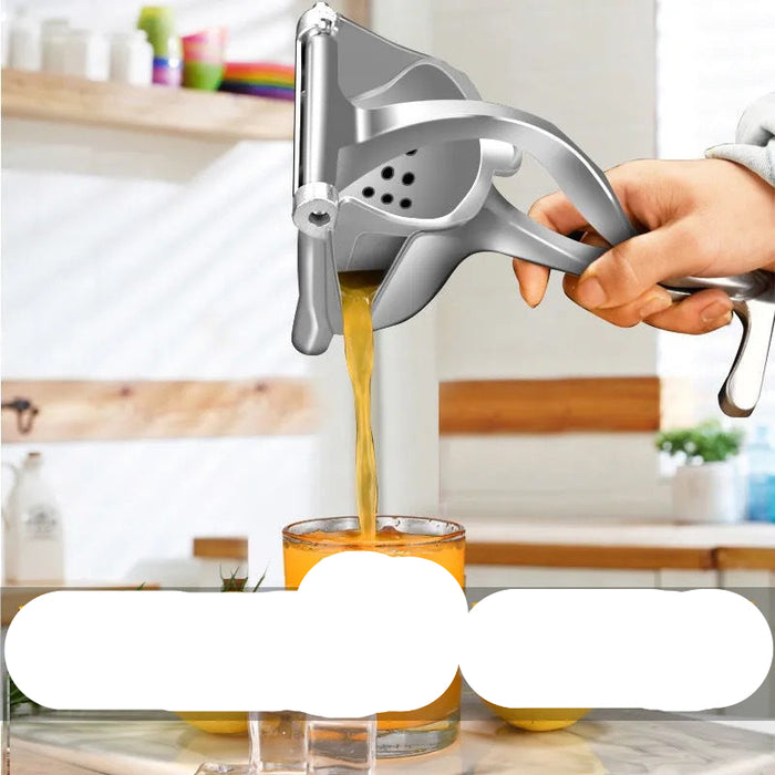 Handheld manual juicer squeezing orange juice into a glass with a blurred kitchen background.