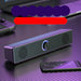 Black speaker bar on a reflective surface with a purple and red blurred area