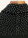 Black fabric with white polka dots on a wooden surface