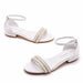 White sandals with pearl embellishments on a white background