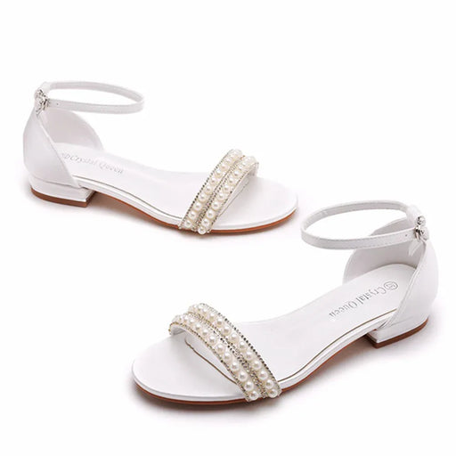 White sandals with pearl embellishments on a white background
