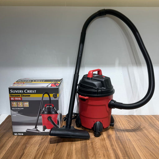 Red and black vacuum cleaner with a black hose on a wooden surface, next to its packaging box.