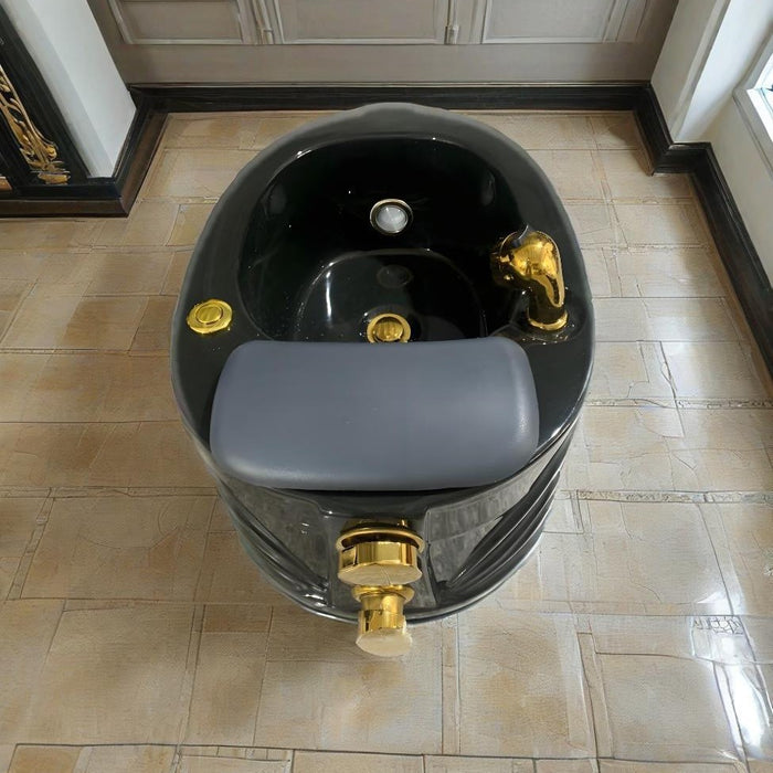 Black and gold sink with gray seat on a tiled floor