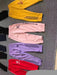 Set of colorful tracksuits with brand logos on a gray surface
