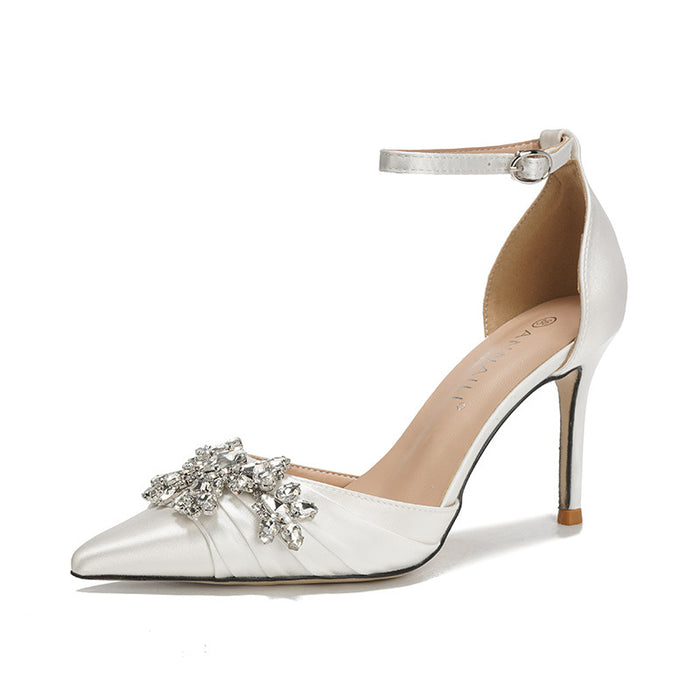 White high-heeled shoe with embellishments on a white background