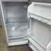 Empty white refrigerator with open door on a speckled countertop