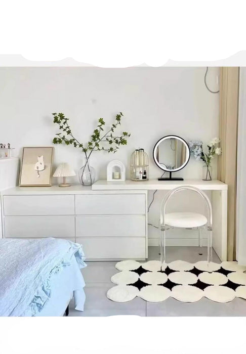 Modern bedroom with white dresser, mirror, and decorative items.