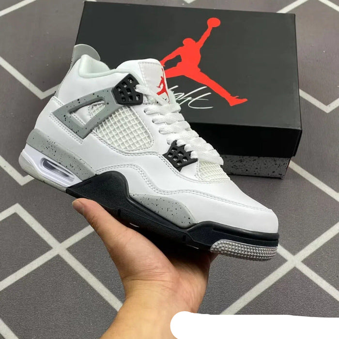 White sneaker with black and gray accents held by a hand, Jordan box in the background