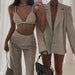 Two outfits in beige tones worn by a person, one with a bralette and pants, the other with a blazer and shorts, against a white background.