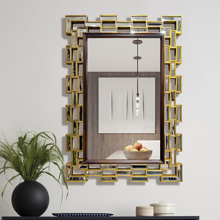 Decorative wall mirror with geometric frame on a light gray wall.