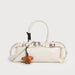 White handbag with a brown dog-shaped charm on a light gray background