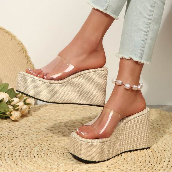 Beige platform sandals worn with light blue jeans on a neutral background