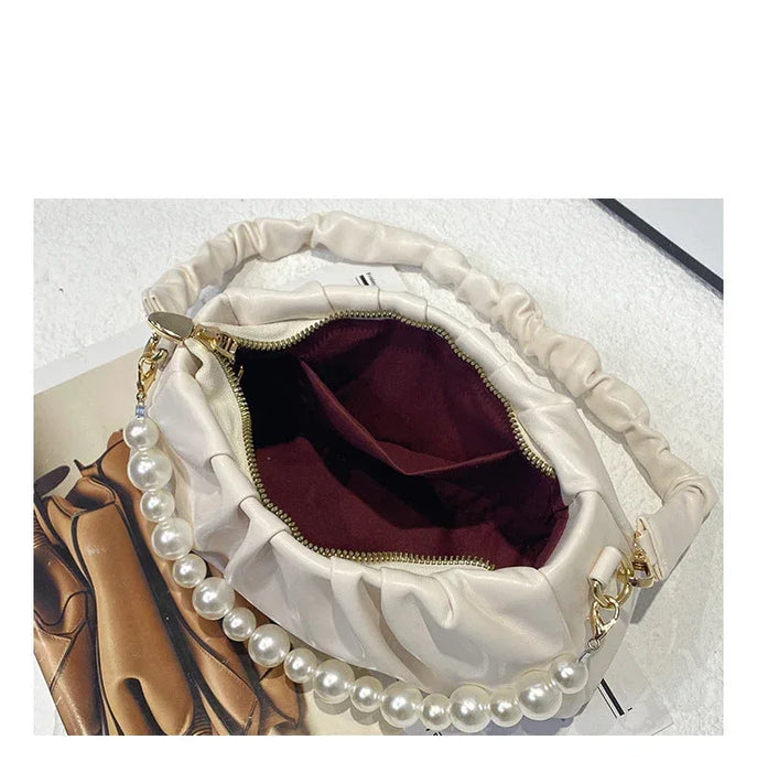 White handbag with pearl details on a white background