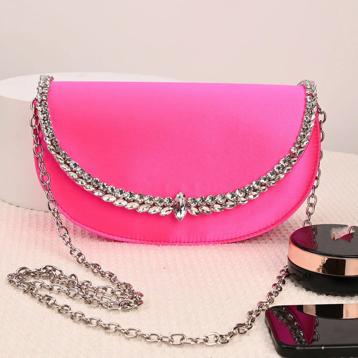 Pink handbag with silver chain on a white surface