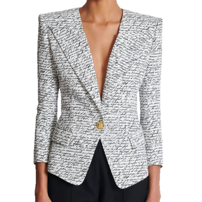 Black and white patterned blazer with a gold button on a white background
