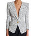 Black and white patterned blazer with a gold button on a white background
