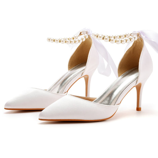 White high-heeled shoes with ankle straps on a white background