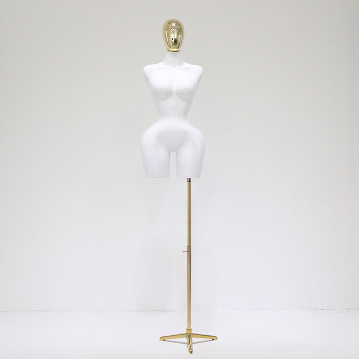 White mannequin torso on a gold stand against a white background
