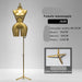 Gold female mannequin with stand on a gray background