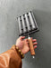 Hand holding a metal tool with wooden handle against a gray background